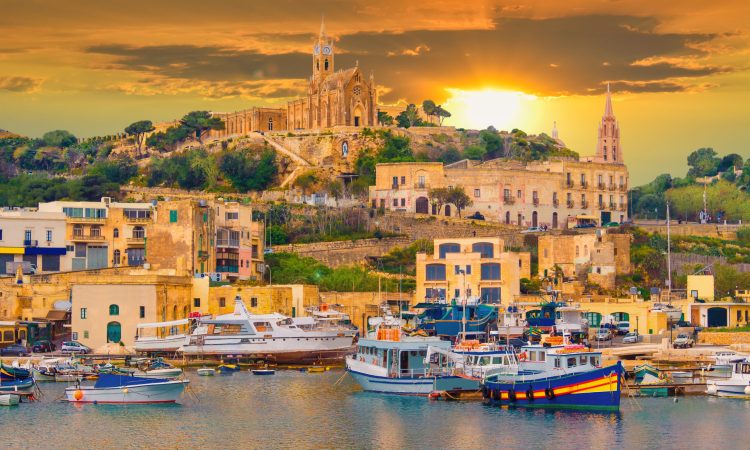 Beautiful cityscape over Gozo island, medieval architecture of castle and boats on the harbor of Malta